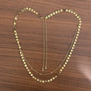 Macro detail of 18K gold-plated double-layer body chain with metal sequins and lobster clasp