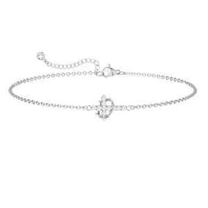 Macro detail of silver bracelet featuring a sparkling orb cross pendant with zircon stones