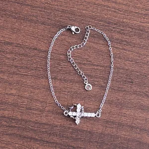 Macro detail of silver cross bracelet with cubic zirconia inlay and adjustable link chain