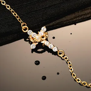 Macro detail of 18K gold bracelet featuring a crown charm with clear zircon stones