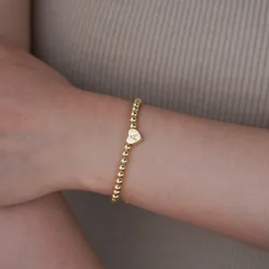 Detailed macro view of 18K gold plated bead bracelet with heart initial A charm