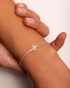 Macro shot of a silver butterfly charm bracelet with sparkling zircons on wrist