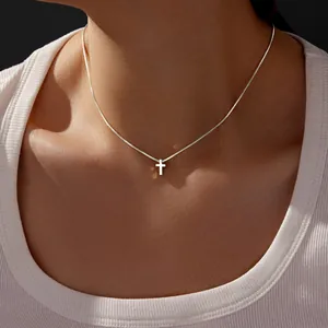 Primo piano della collana con ciondolo a croce in acciaio inox su collo donna