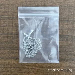 Collana con ciondolo croce Ankh d'argento e catena sottile su fondo di legno