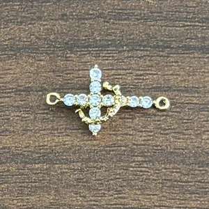 Macro shot of 18K gold-plated cross anchor connector with micro-set cubic zirconia