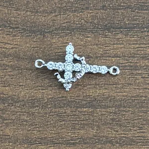 Detail view of a zircon cross connector with anchor motif on dark wood background
