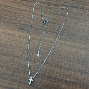 Dettaglio catena veneziana in acciaio inossidabile argento con mini ciondolo a croce