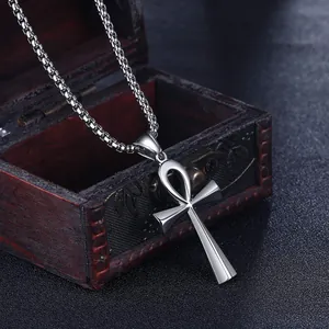 Dettaglio del ciondolo croce Ankh in argento con catena su scatola in legno vintage
