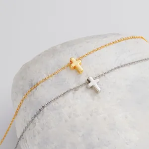 Dettaglio ravvicinato dei ciondoli a croce in oro e argento su superficie di marmo bianco