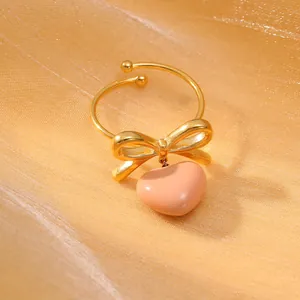 Dettaglio dell'anello a fiocco placcato oro con un ciondolo a forma di cuore rosa