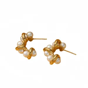 Elegant gold twisted wire stud earrings with white pearls in a luxurious modern design