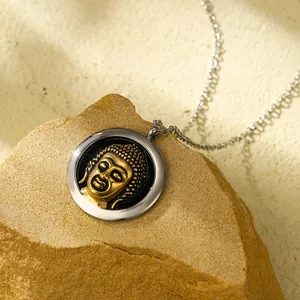 Vintage round gold Buddha head pendant necklace in stainless steel on a natural rock