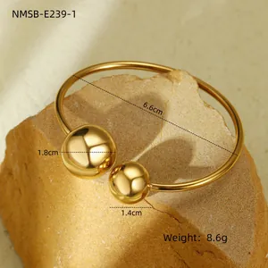 Détail d'un bracelet jonc doré irrégulier avec des sphères de 1,8cm et 1,4cm de 8,6g