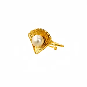 Anello a conchiglia in titanio dorato con grande perla marina bianca su sfondo bianco