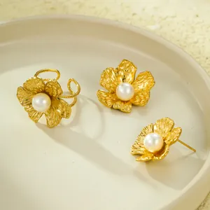 Ensemble élégant boucles d'oreilles et bague fleur dorée avec perles sur plateau