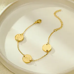 Détail d'un bracelet en acier doré avec calligraphie arabe gravée sur des disques ronds