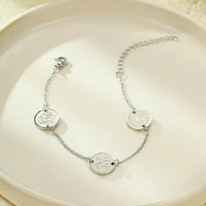 Détail du bracelet en acier inoxydable avec trois pendentifs en calligraphie arabe