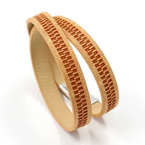 Detail of light brown double-wrap PU leather bracelet with embossed zipper pattern