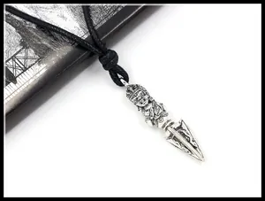 Macro shot of silver alloy Phurba pendant necklace with intricate deity carving