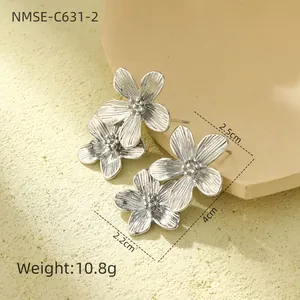 Détail macro de boucles d'oreilles fleurs argentées avec pétales texturés et perles