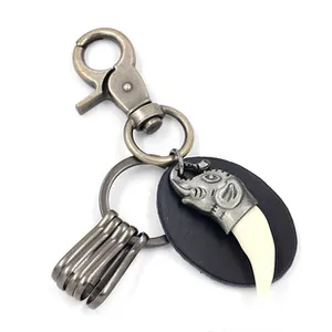 Detail of vintage bronze keychain with elephant charm and leather strap tag