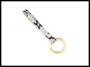 Detailed close-up of navy blue and white snakeskin PU leather keychain with gold metal ring
