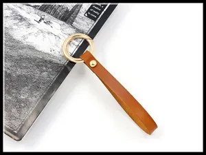 Detail of brown leather strap with golden alloy spring ring and vintage rivet texture