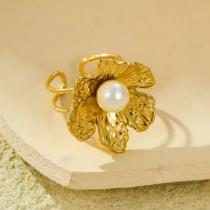 Détail macro de la texture de pétale dorée et de la perle sur la bague ajustable