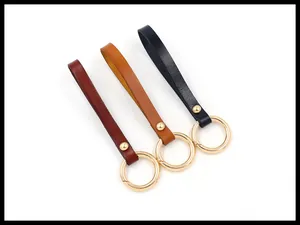 Detailed view of leather keychains in brown and black with golden spring O-rings