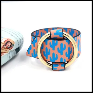 Detail of wide faux leather bracelet featuring cactus print and golden metal ring