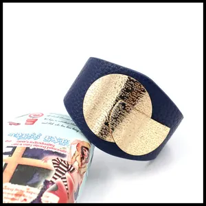 Detail van blauwe lederen manchet met getextureerde ronde goudkleurige versiering
