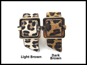 Detalle de pulseras de cuero con estampado de leopardo y hebillas doradas grandes