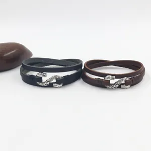 Close-up of retro punk snake-head buckles on black and brown braided leather bracelets