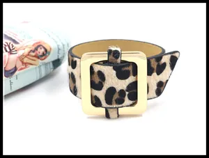 Primer plano de pulsera ancha de pelo de poni con leopardo y hebilla dorada pulida