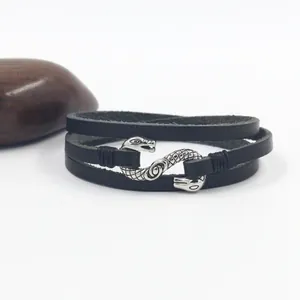 Macro detail of multi-layer black leather bracelet with retro silver snake head buckle