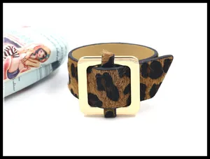 Detalle de brazalete con estampado de leopardo y una gran hebilla cuadrada de metal dorado
