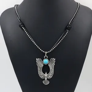 Close-up of vintage eagle pendant with blue stone inlay and double-layered chains