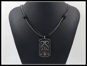 Detail of a vintage layered men's necklace with engraved dog tag and black leather cord