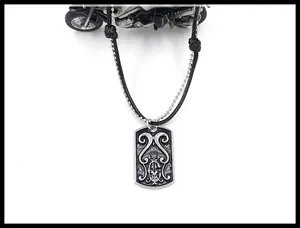 Detail of vintage silver dog tag pendant with floral relief and dual chain design