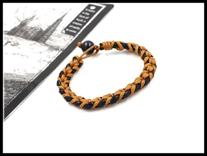Detail van handgemaakte gevlochten armband met zwarte parelsluiting en tweekleurig vezelweefsel