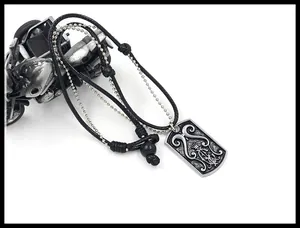 Detail of a vintage punk alloy pendant necklace featuring a crown embossed tag on leather cord