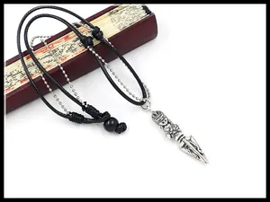 Close-up of retro ethnic pendant necklace with woven leather cord and silver bead chain