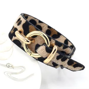 Detail of leopard print PU leather bracelet with polished gold-tone buckle closure