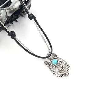 Wolf head pendant necklace with turquoise stone and woven leather chain on white background