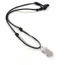 Detail of skateboard pendant with cross engraving on double-layered leather cord necklace