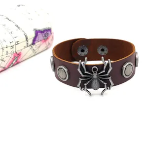Gros plan du bracelet punk en cuir marron avec araignée en métal et clous argentés