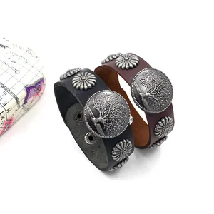 Détail de bracelets en cuir vintage avec charmes Arbre de Vie et rivets en métal