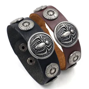 Detail van leren armbanden met spinnenmotieven en retro zilveren drukknoopsluitingen