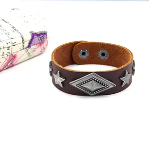 Detalle de pulsera de cuero marrón oscuro con remaches metálicos de estrella y rombo