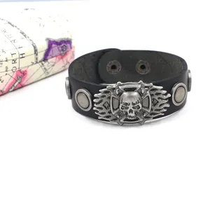 Detail of wide black leather punk bracelet with silver skull emblem and metal studs